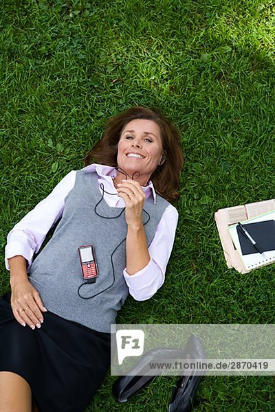 Eine Frau in einem Park mit einem Mobiltelefon Stockholm Schweden.