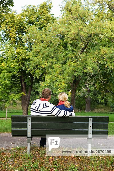 Ein paar auf einer Bank im Park Schweden sitzen.