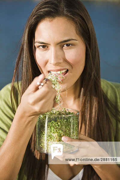 Porträt einer Frau  die Bohnensprossen isst
