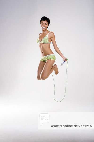 Porträt einer Frau  die mit einem Seil hüpft