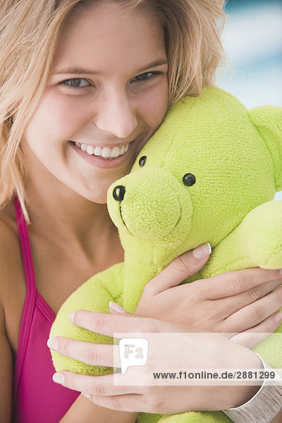 Porträt einer Frau mit Teddybär und lächelndem Gesicht