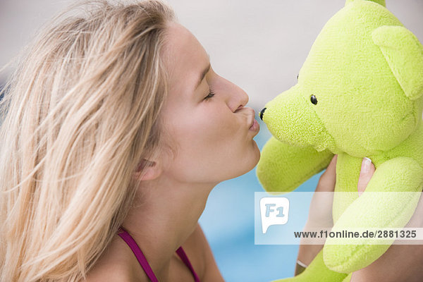 Nahaufnahme einer Frau beim Küssen eines Teddybären