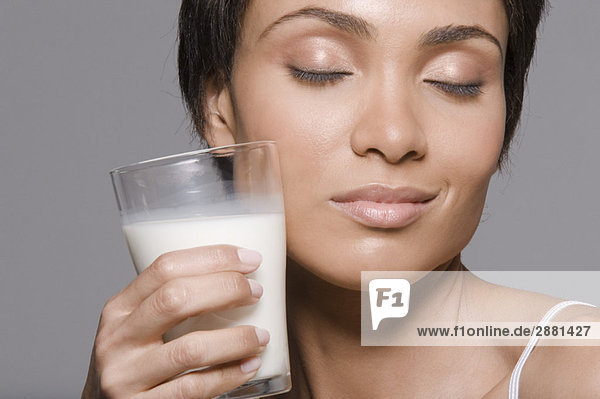 Close-up of a woman holding a glass of milk