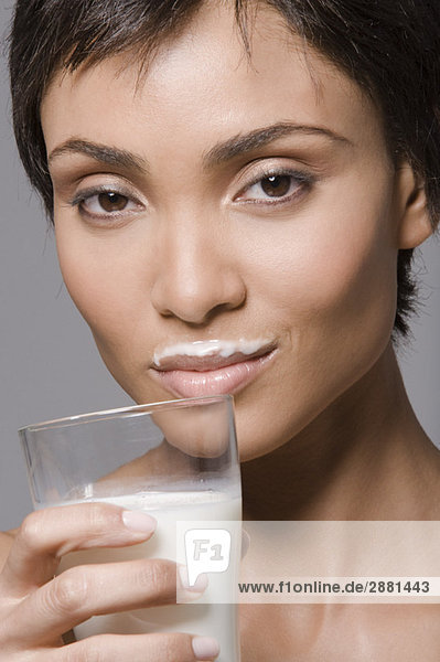 Porträt einer Frau  die Milch aus einem Glas trinkt