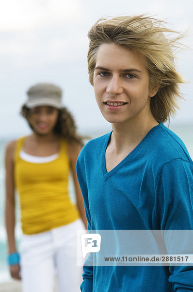 Teenager-Junge steht mit einem Mädchen am Strand