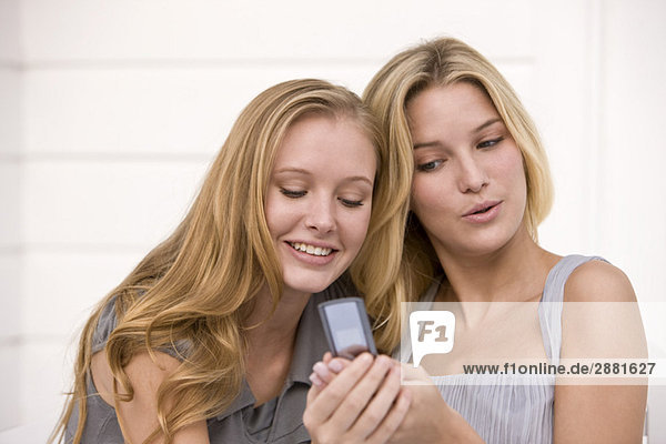 Zwei Frauen beim Lesen von Nachrichten auf dem Handy