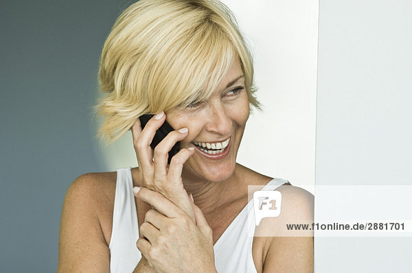 Frau  die auf dem Handy spricht und lacht