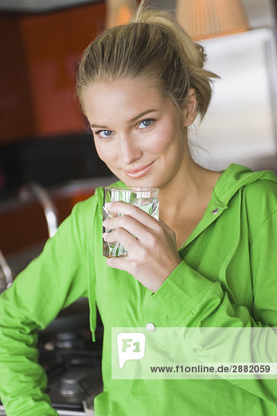 Porträt einer Frau  die Wasser aus einem Glas trinkt