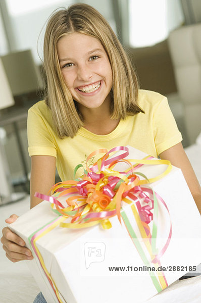 Mädchen mit Geburtstagsgeschenk und Lächeln