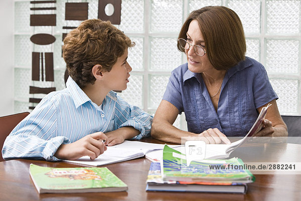 Frau hilft ihrem Enkel bei den Hausaufgaben
