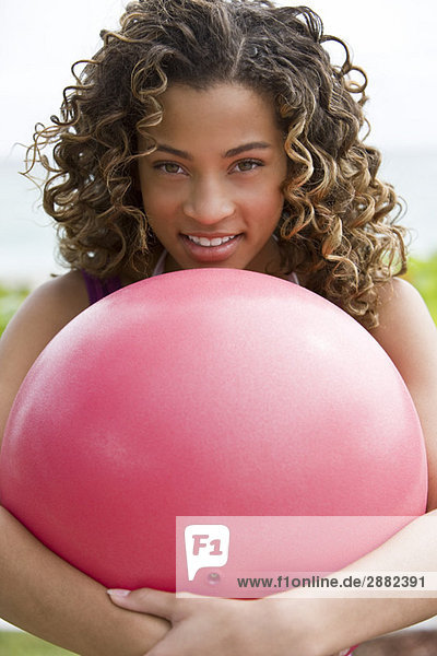 Porträt eines Mädchens  das einen Ball umarmt und lächelt