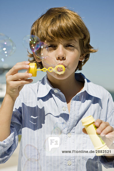 Boy blowing bubbles with a bubble wand