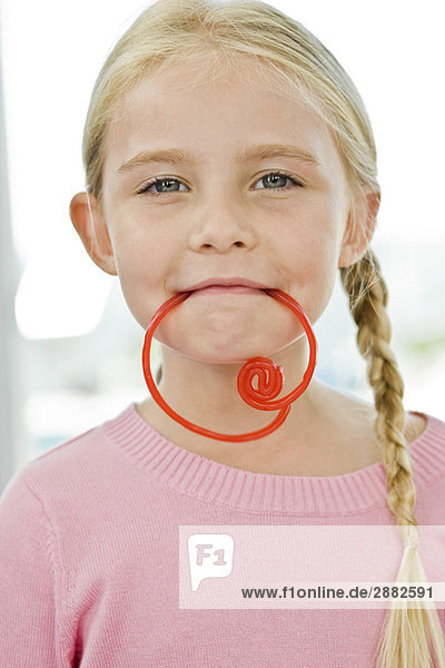 Porträt eines Mädchens mit einem Bonbon im Mund