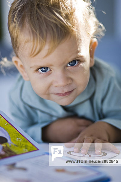Porträt eines kleinen Jungen beim Lesen eines Bilderbuches