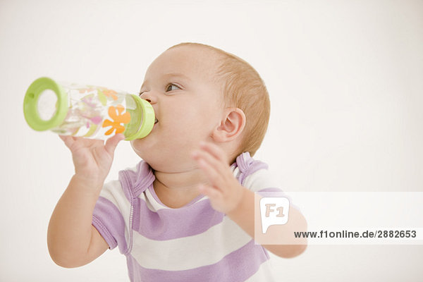 Baby Mädchen trinkt Wasser aus einer Babyflasche