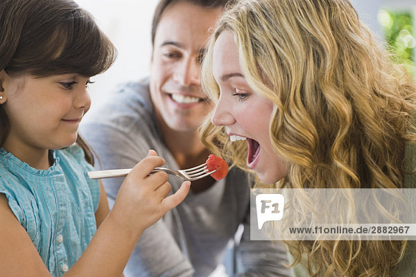 Mädchen füttert ihre Mutter mit Obstsalat