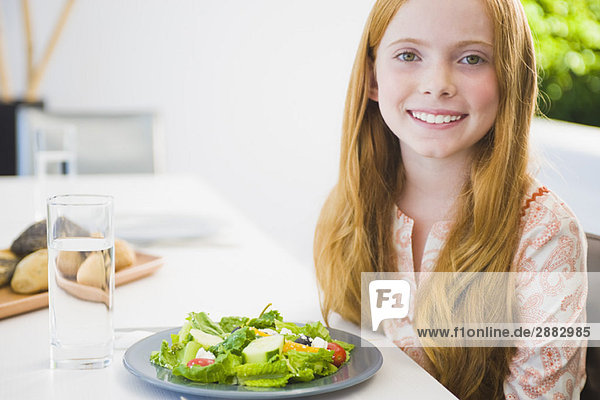 Porträt eines Mädchens beim Salatessen und Lächeln