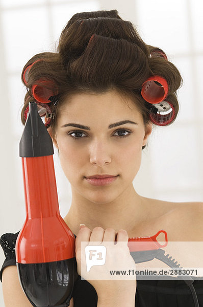 Portrait of a woman holding a hair dryer