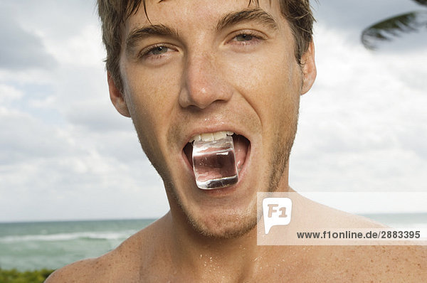 Porträt eines Mannes mit Eiswürfel im Mund