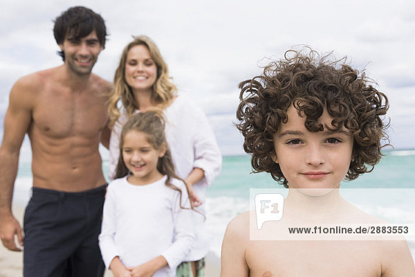 Portrait eines Jungen mit seiner Familie im Hintergrund