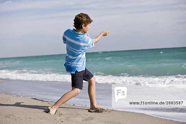 Boy throwing a stone into the sea