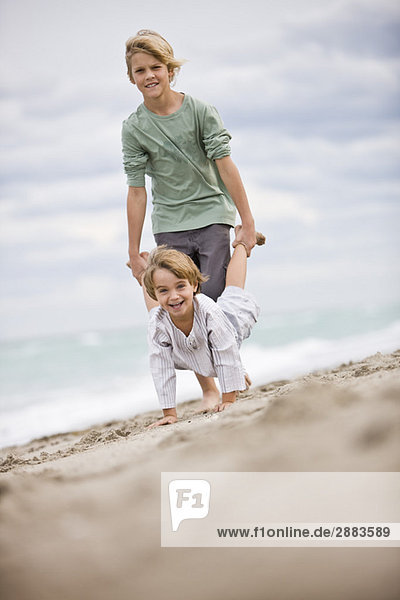 Zwei Jungen spielen am Strand