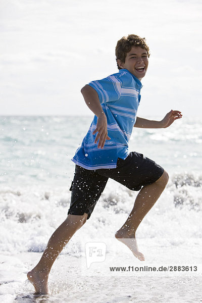 Junge  der am Strand rennt