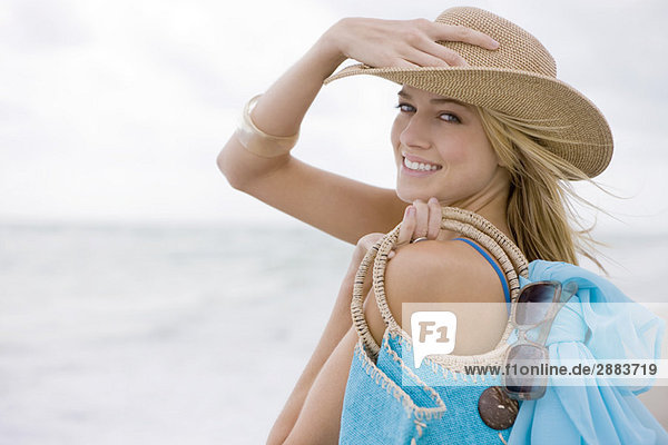 Frau mit einer Tasche am Strand