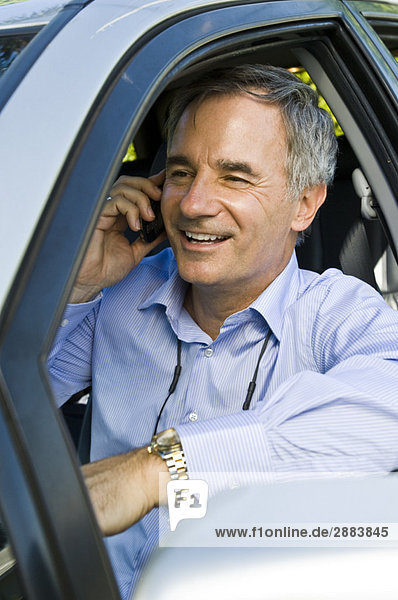 Man in a car and talking on a mobile phone
