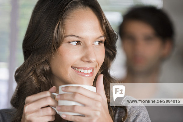 Frau hält eine Tasse Tee und lächelt