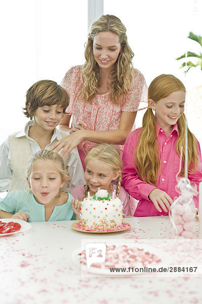 Girl celebrating her birthday with her mother and friends