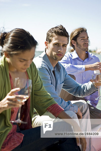 Drei Freunde genießen Getränke auf einer Party