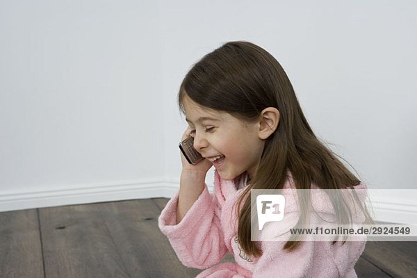 Ein junges Mädchen  das mit einem Handy spricht.