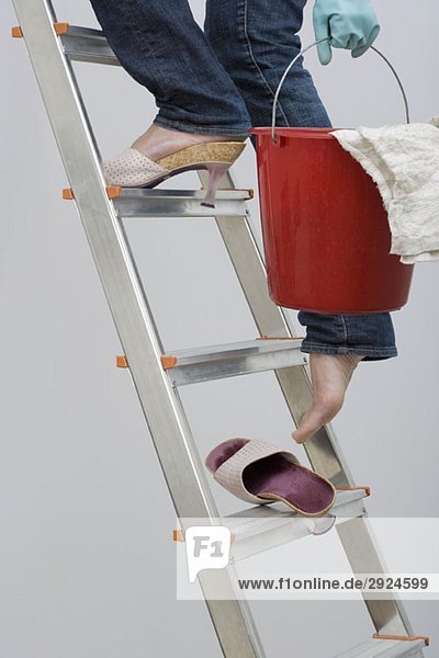 A woman walking up the ladder and losing her shoe