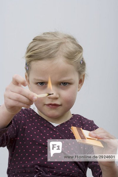 Ein junges Mädchen spielt mit Streichhölzern