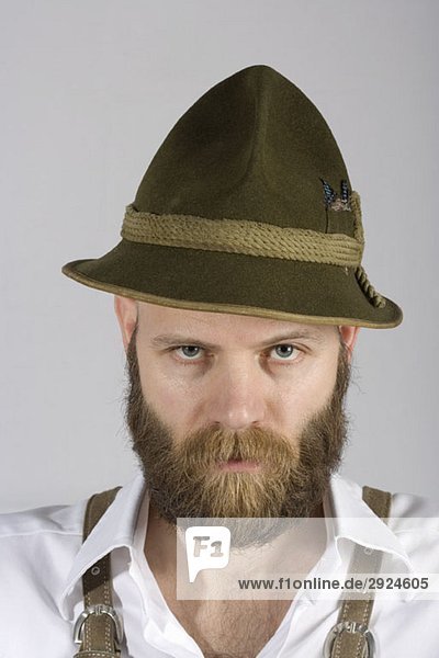 A man wearing an alpine hat and lederhosen