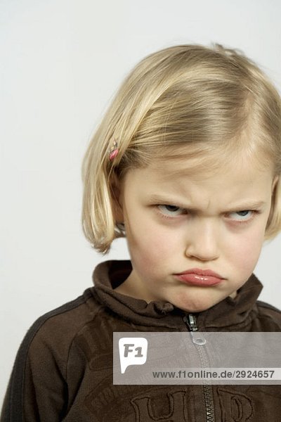 A young girl making an angry face