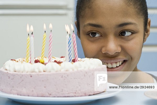 Eine junge Frau beim Anblick eines Geburtstagskuchens