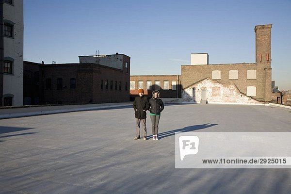 Eine Frau und ein Mann stehen auf einem Dach.
