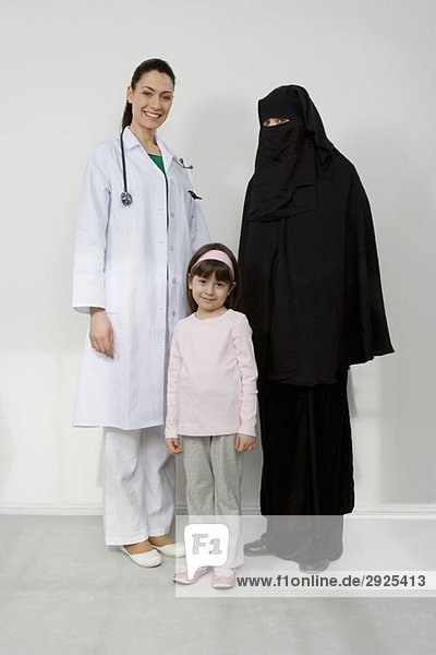 Ein Arzt mit einer Frau im Niqaab und ihrer Tochter