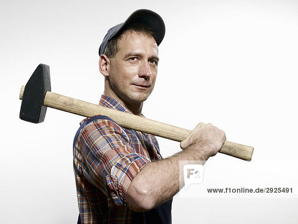 A man holding a sledgehammer over his shoulder