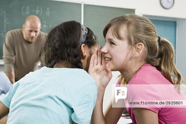 Ein Schulmädchen erzählt einem Freund ein Geheimnis