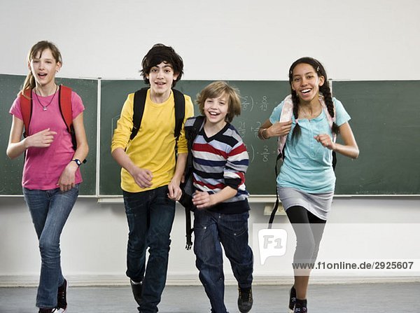 Schülerinnen und Schüler  die zusammen in einem Klassenzimmer laufen