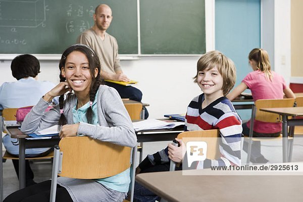 Zwei Schulkinder sitzen in einem Klassenzimmer