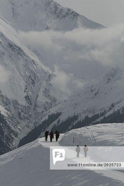 Menschen wandern durch verschneite Berge  Graubünden  Schweiz