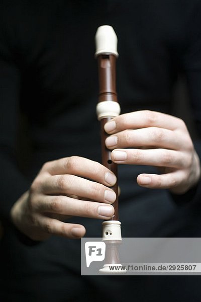 Menschliche Hände beim Blockflötenspiel