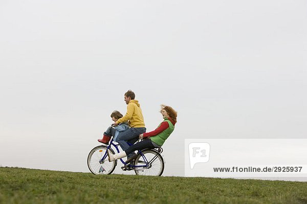 A young family riding on a bike together
