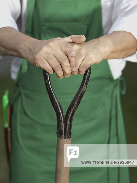 Midsection of a man holding a gardening tool