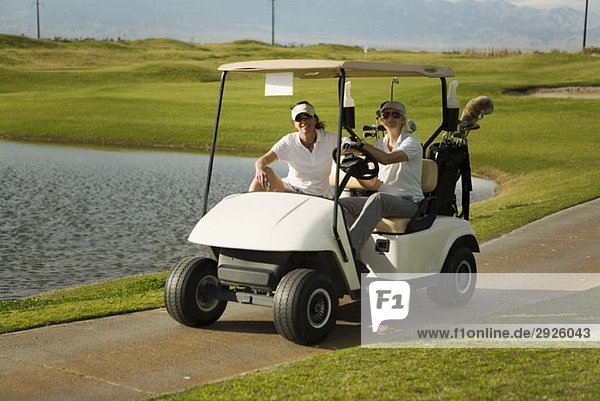 Zwei Golfer im Golfwagen