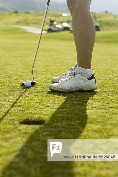 Detail eines Golfspielers beim Putten